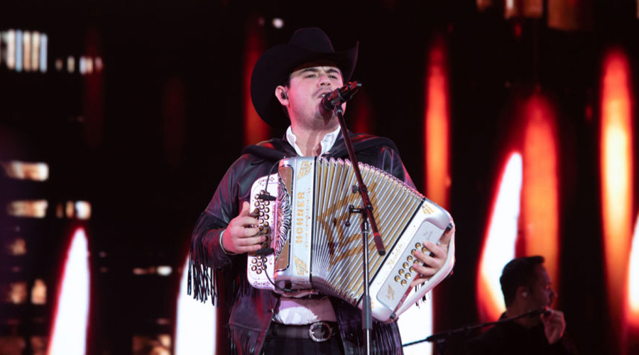 El cantante Alfredo Olivas en un escenario con un acordeón