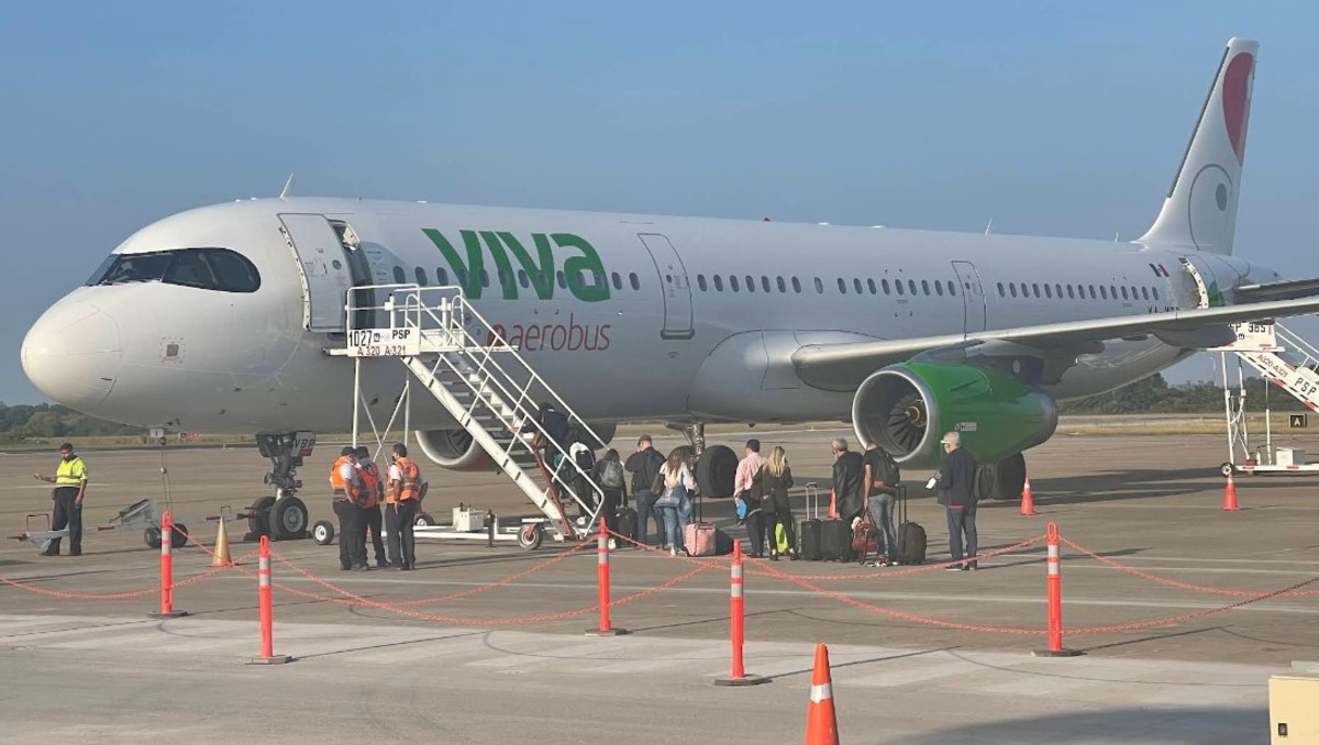 Avión de viva aerobus con una escalera para que suban pasajeros en un aeropuerto