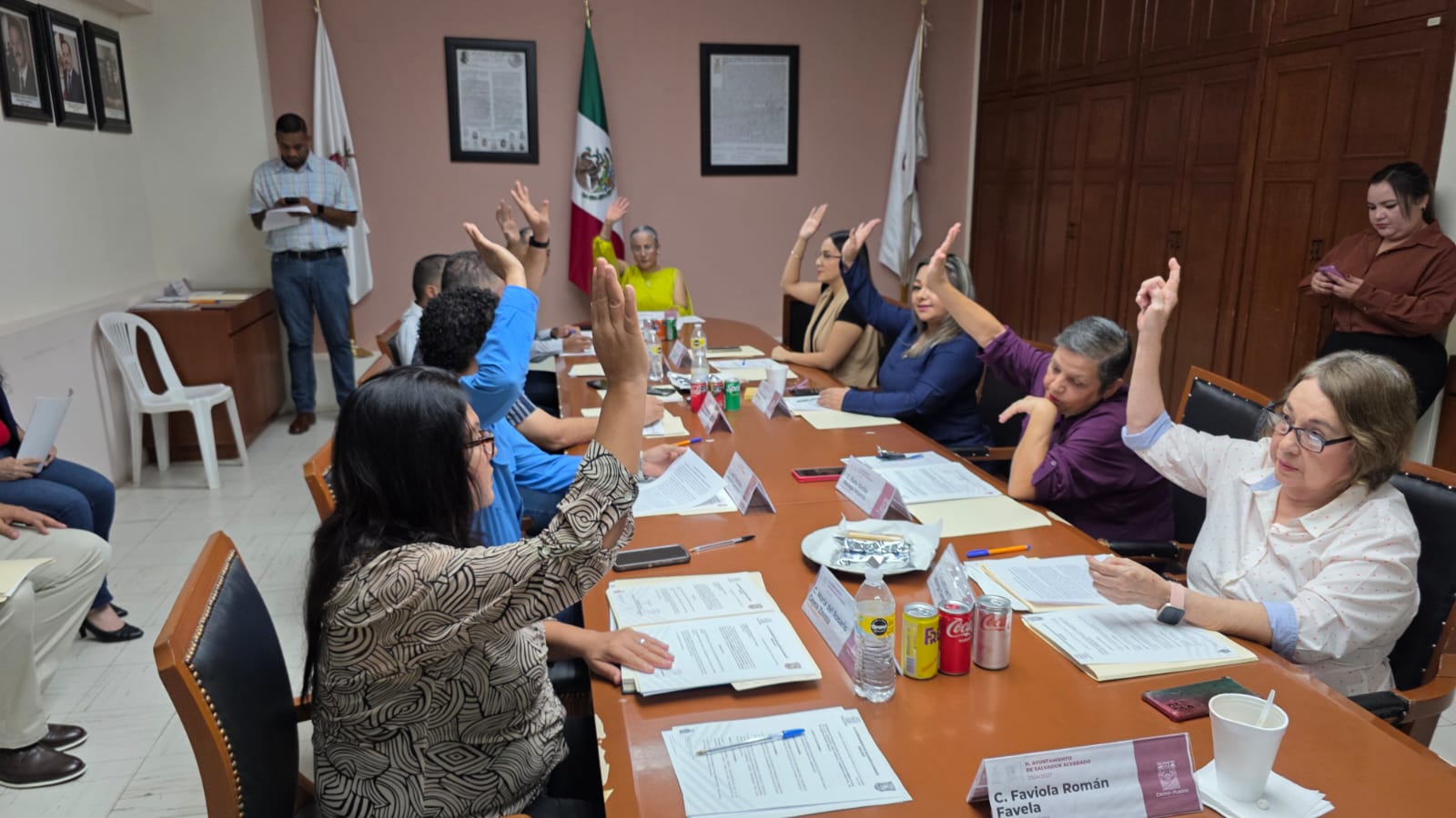 Personas en una reunión levantando la mano