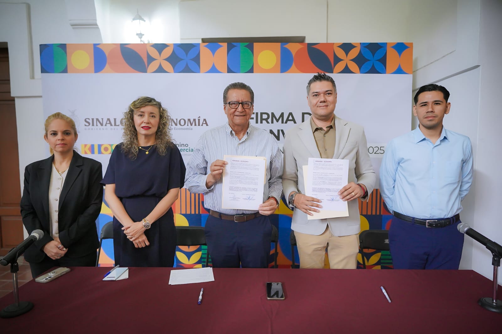 Funcionarios y representantes de Kiosko posando para la foto con el convenio