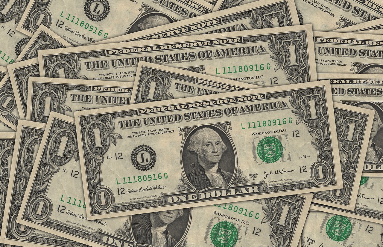 Imagen de muchos billetes de dólar apilados