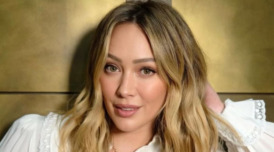 la cantante Hilary Duff con un fondo de color dorado