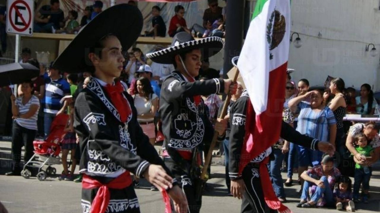 Escolta vestida de mariachi con bandera de México