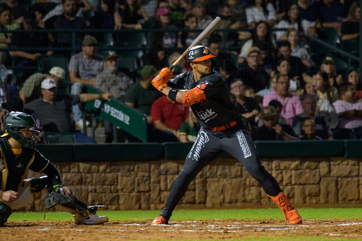 El bateador de los Naranjeros de Hermosillo se prepara para recibir la pelota en un juego ante aficionados