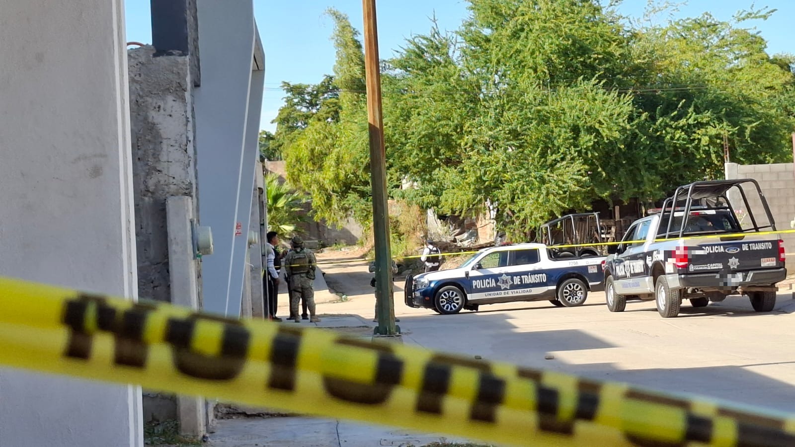 policía Estatal en casa donde ocurrió atentado, se ve cinta amarilla delimitando el área