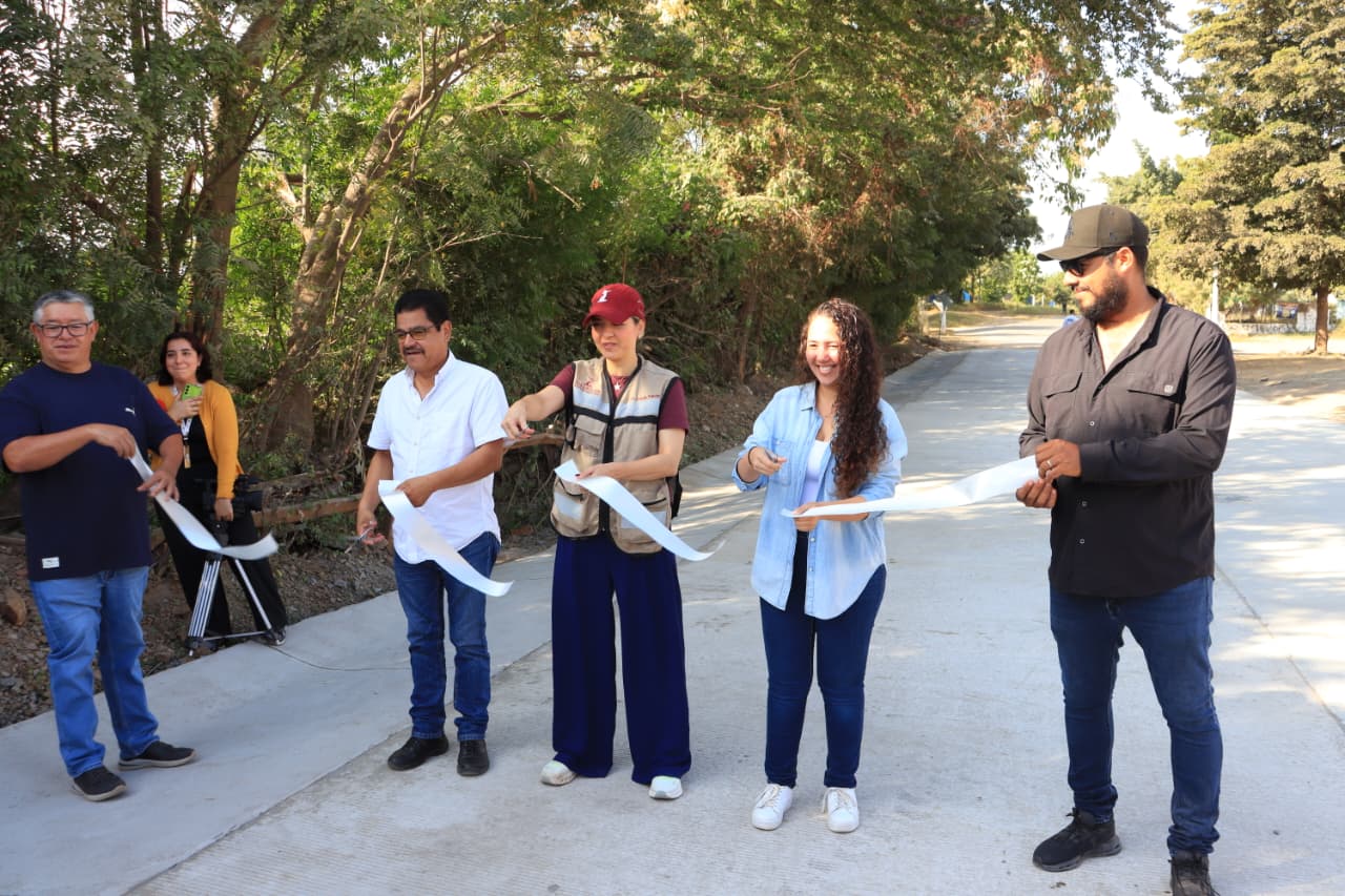 Alcaldesa y personas cortando el listón de la inauguración de una pavimentación
