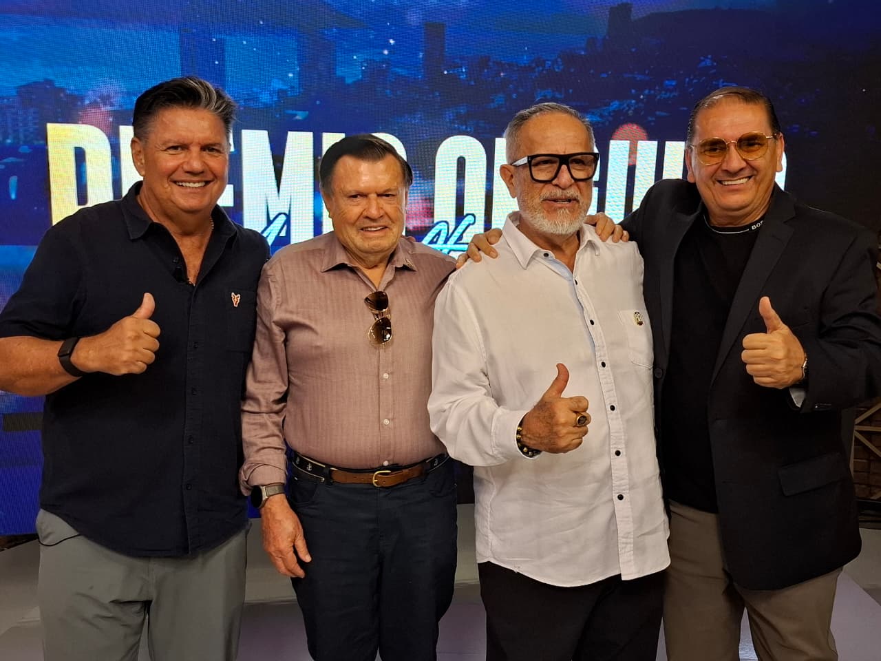 Personas soriendo y levantando el pulgar durante un evento de premiación
