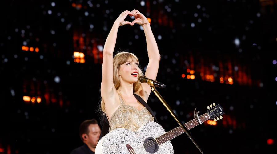 Taylor Swift con forma de corazón con una guitarra en concierto