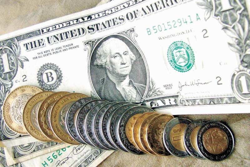 Monedas de pesos mexicanos y billetes de dólar