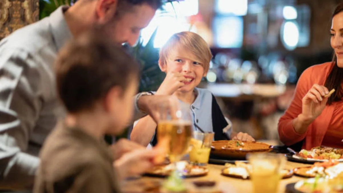 Niños comiendo en restaurante en familia