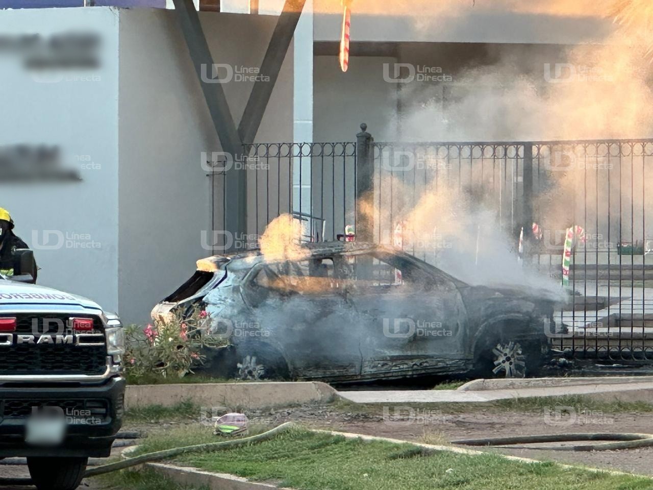 Vehículo con humo luego de ser incendiado afuera de una escuela