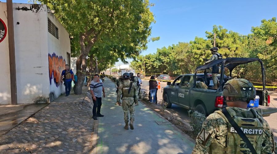 Personal del Ejército Mexicano junto a más personas en una calle y hay un cuerpo tirado