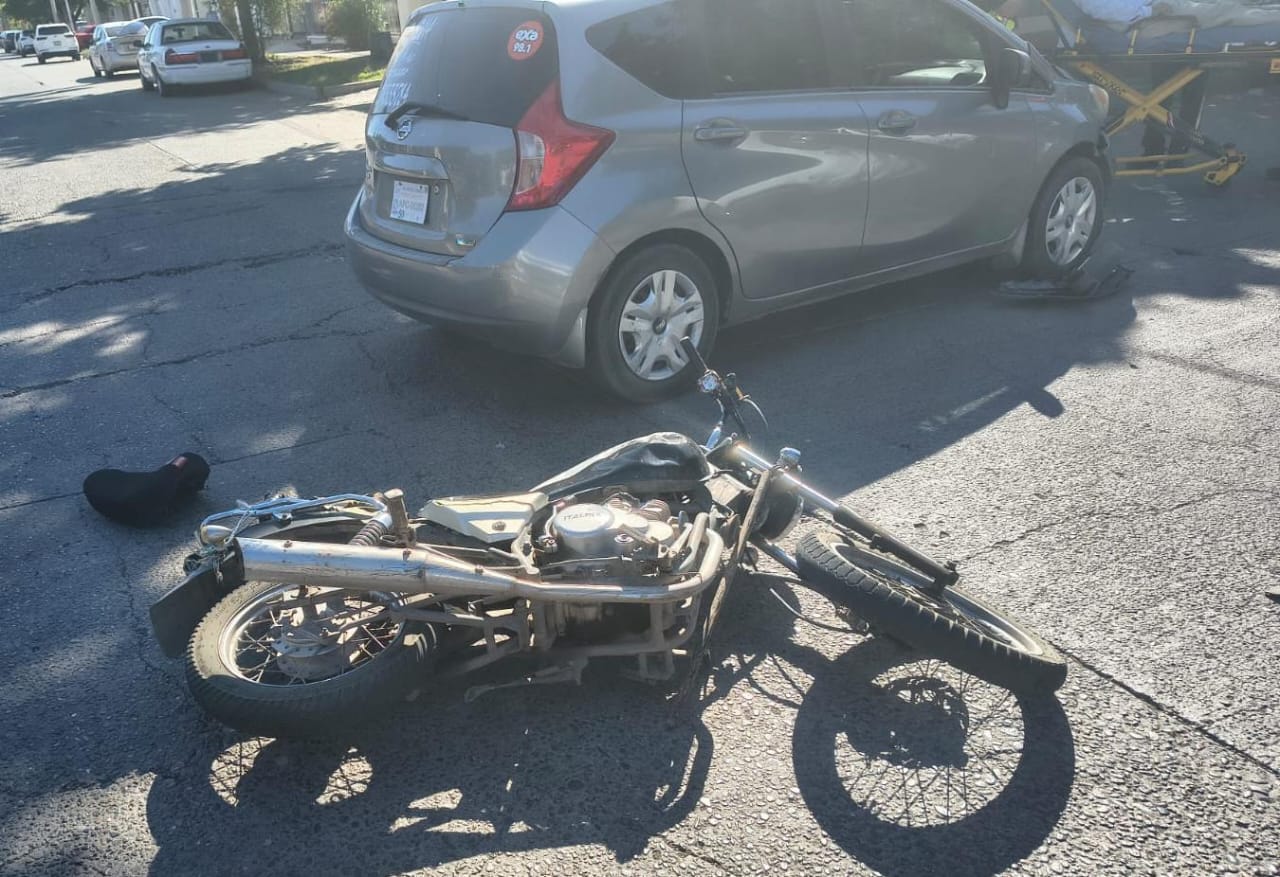 Motocicleta tirada junto a un casco y un carro