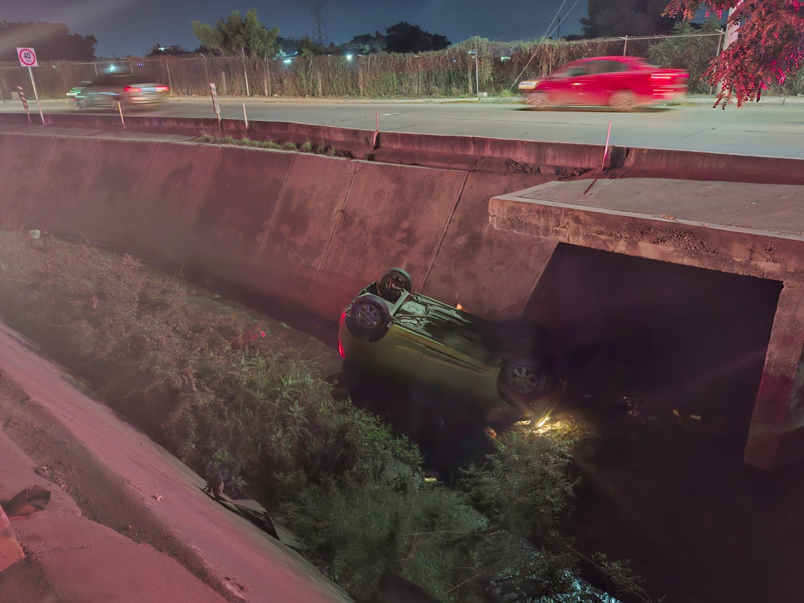 Canal pluvial y un carro volcado dentro