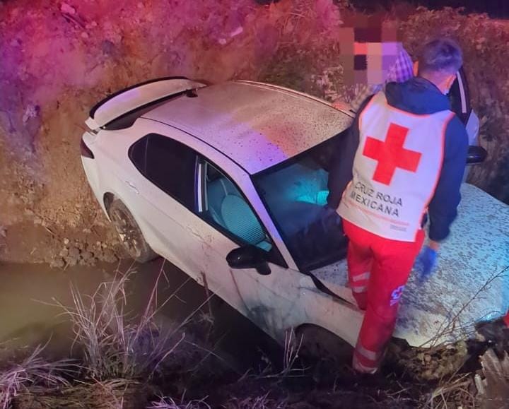 Paramédico de Cruz Roja poniendo un pie sobre un carro accidentado