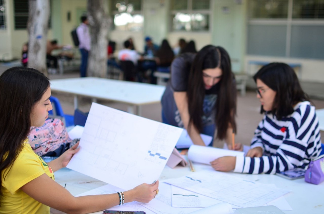 Jóvenes realizado trabajos en una mesa en una escuela