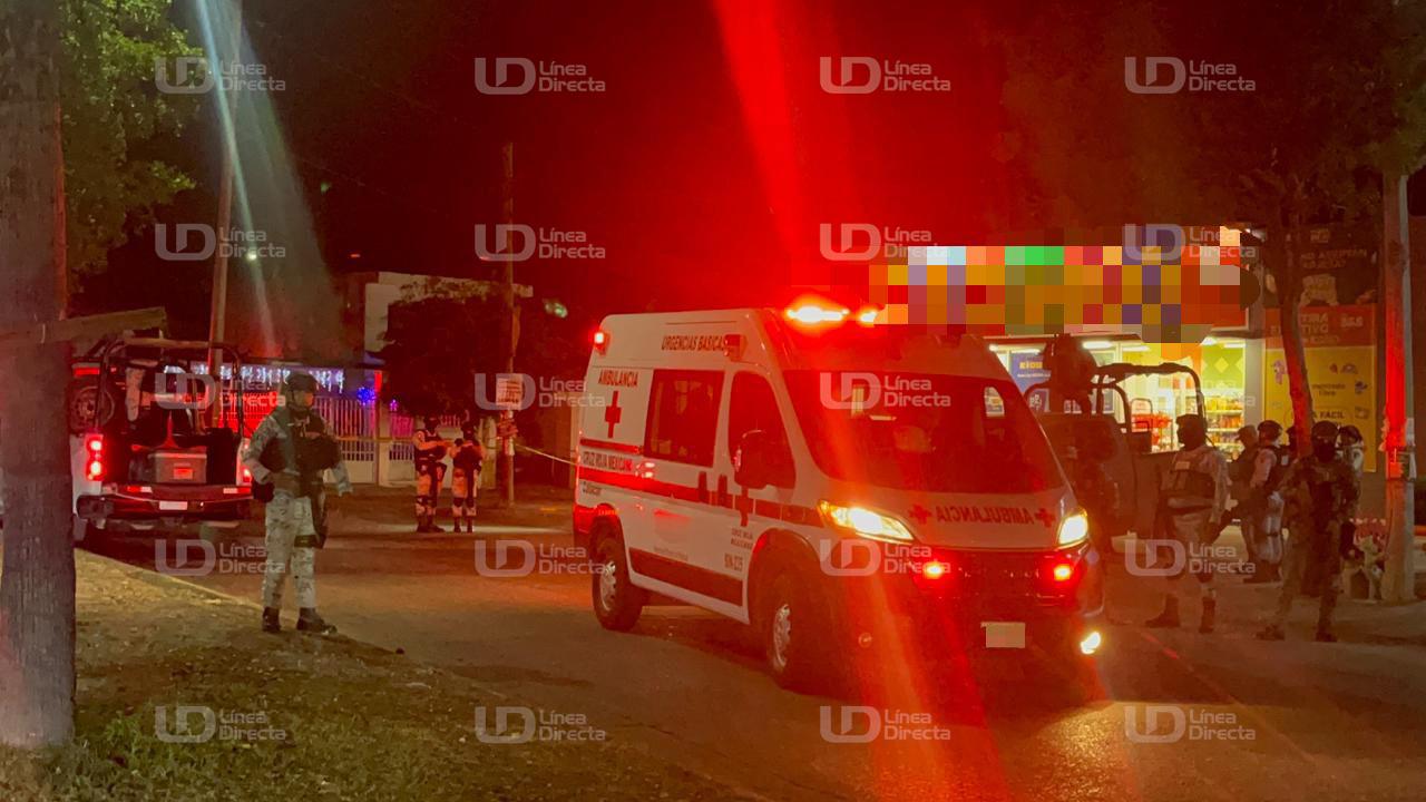 Unidad de la Cruz Roja con luz roja encendida, elementos del Ejército Mexicano en el lugar y una tienda de conveniencia de noche
