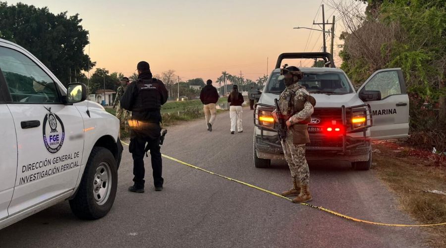 Elementos de seguridad junto a unidades policiacas en una calle a lado de un canal