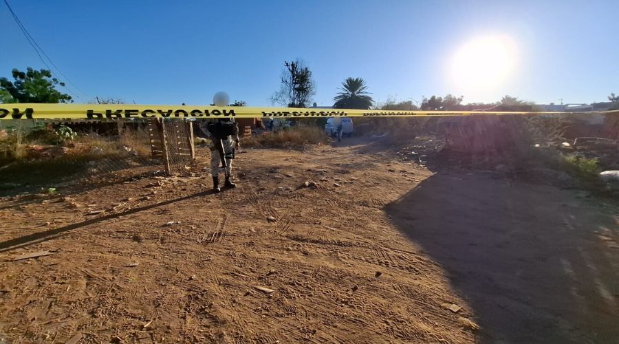 Cinta amarilla de precaución en una ladrillera en terracería, se observan elementos policiacos