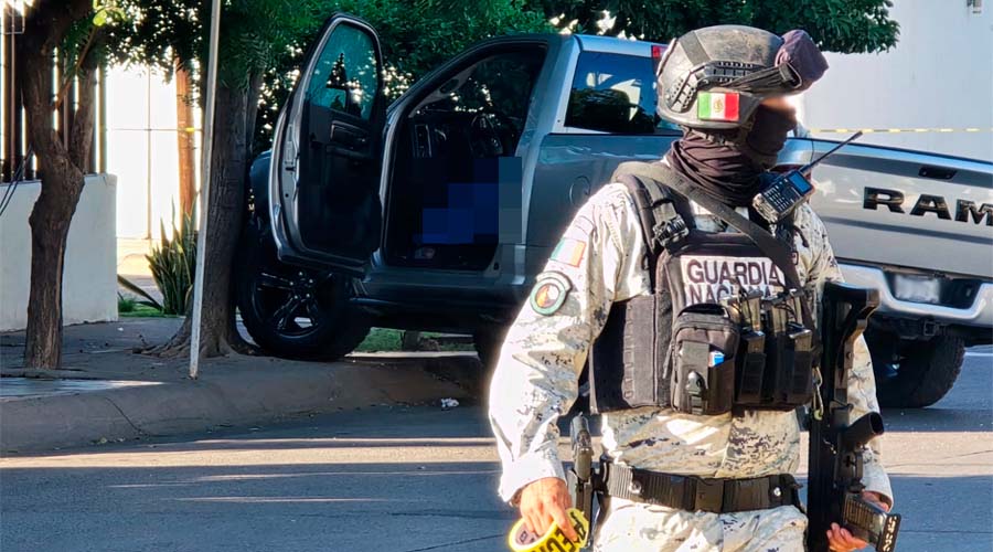 Elemento de la Guardia Nacional sostiene cinta para asegurar perímetro en lugar de ataque armado, en Culiacán
