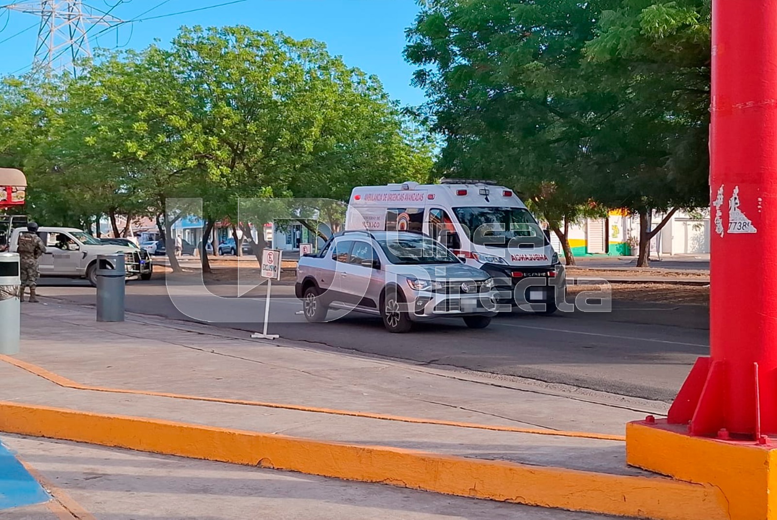 Vehículo gris y una ambulancia en una calle