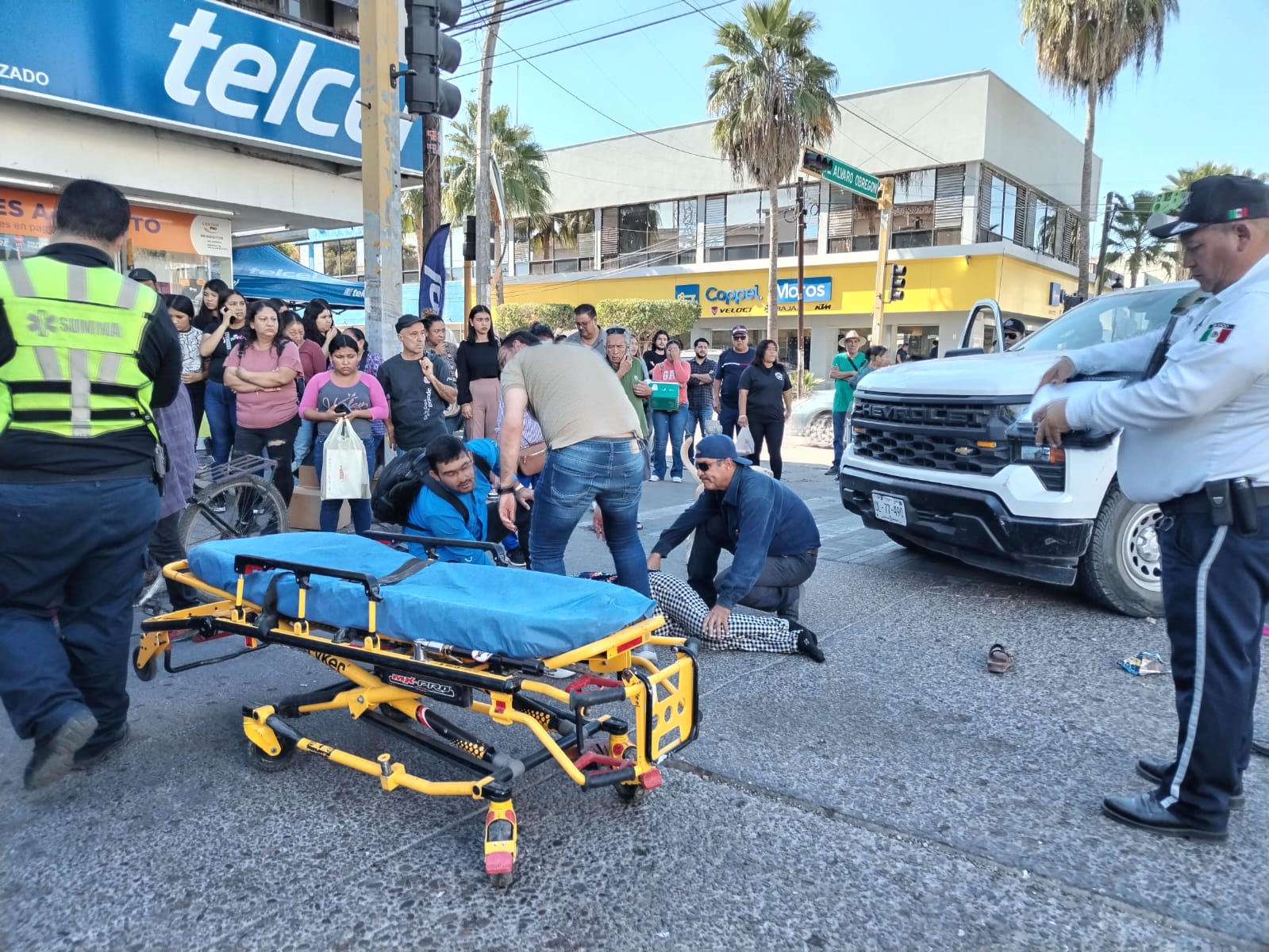 Personas viendo el accidente y un paramédico con una camilla