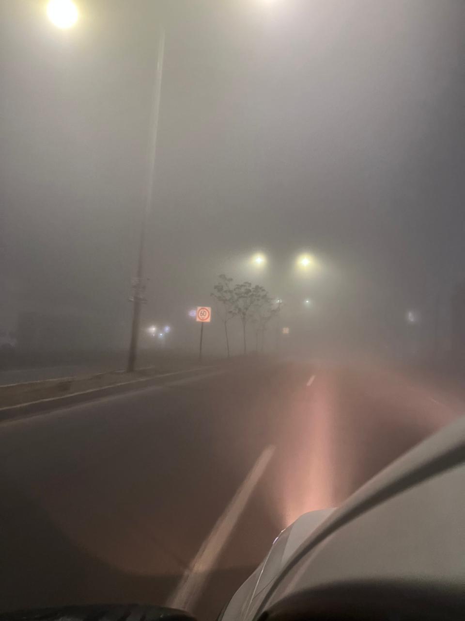 Luces de carro y luminarias entre la densa neblina