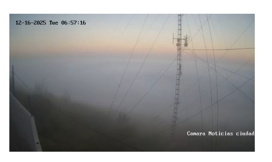 Foto panoramica en la que observa una ántena y cables entre la densa neblina