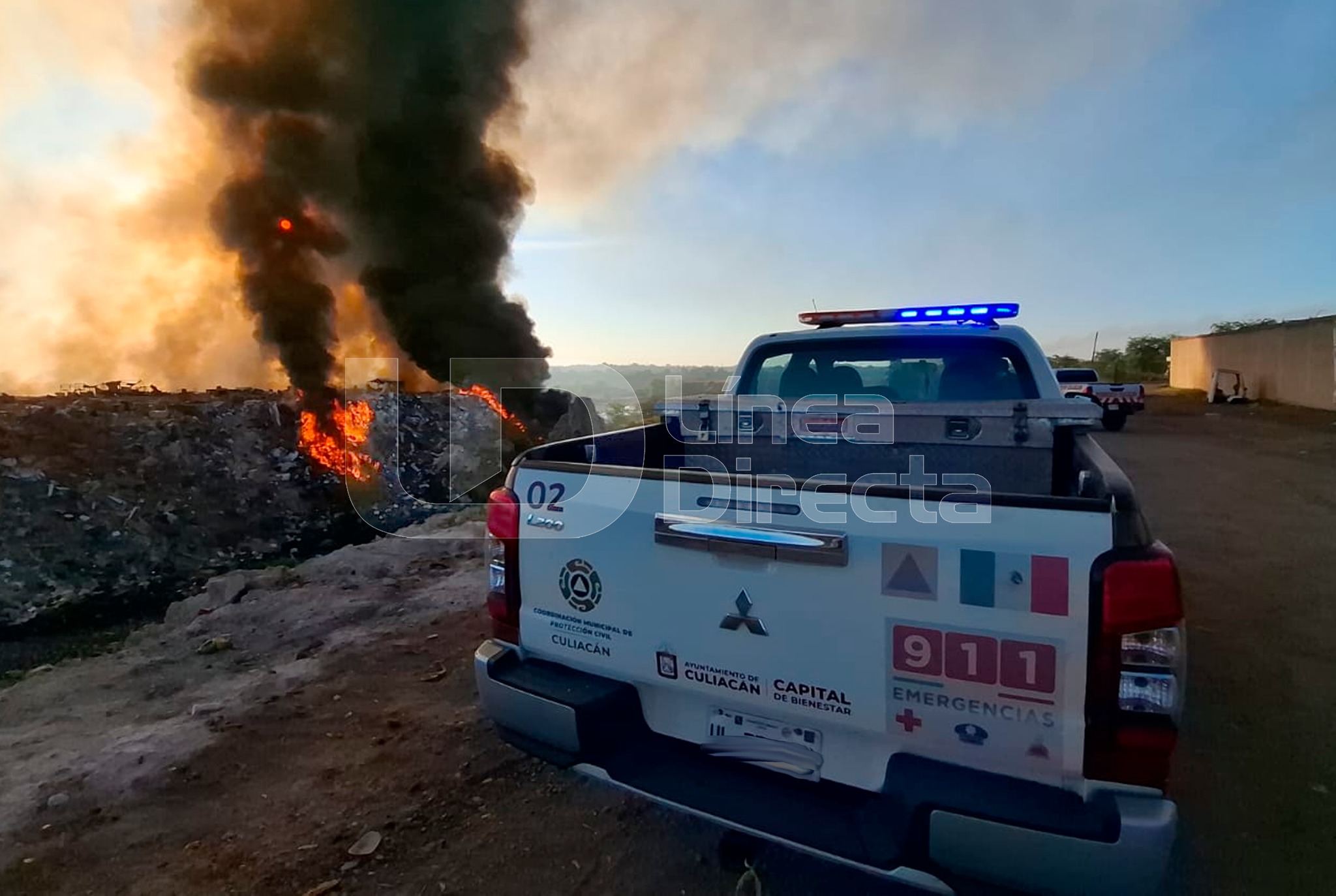 Unidad de emergencias frente a un incendio en un basurón