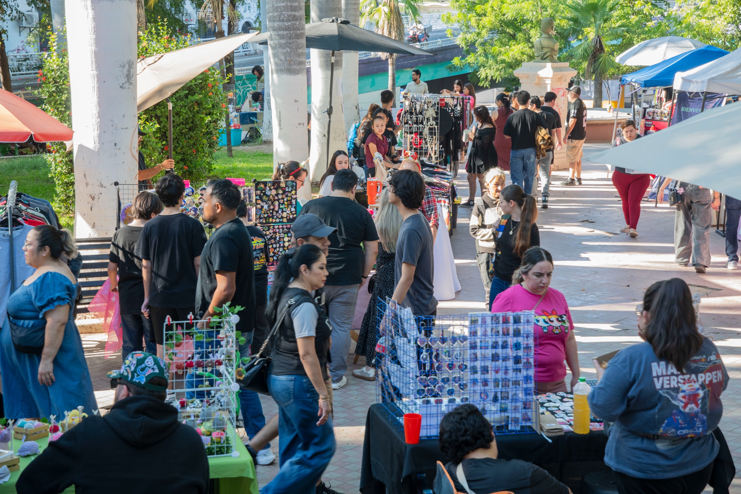 Plaza de Culiacán donde se ven varios puestos de venta y personas transitando por el lugar observando lo que se vende
