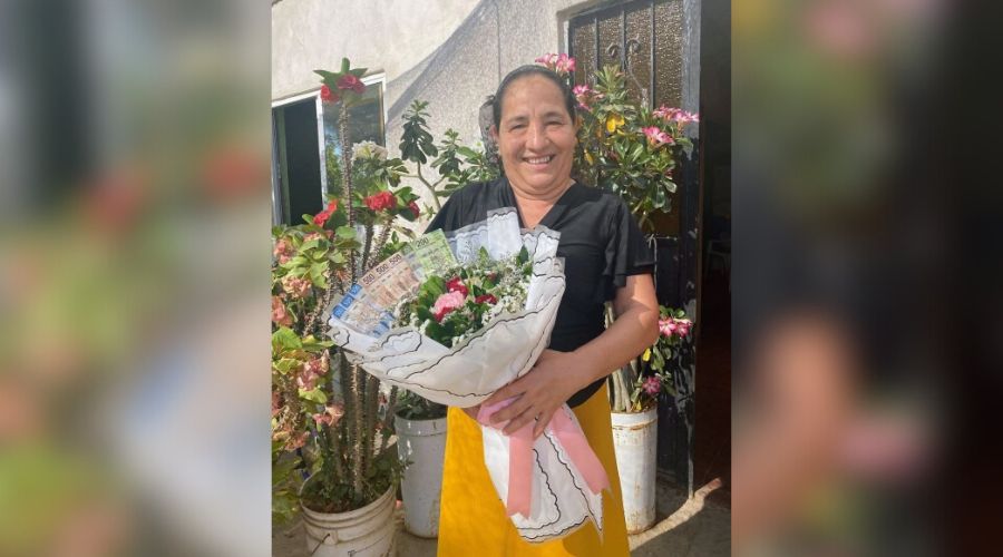 Mujer con un ramo de flores con billetes en un jardín