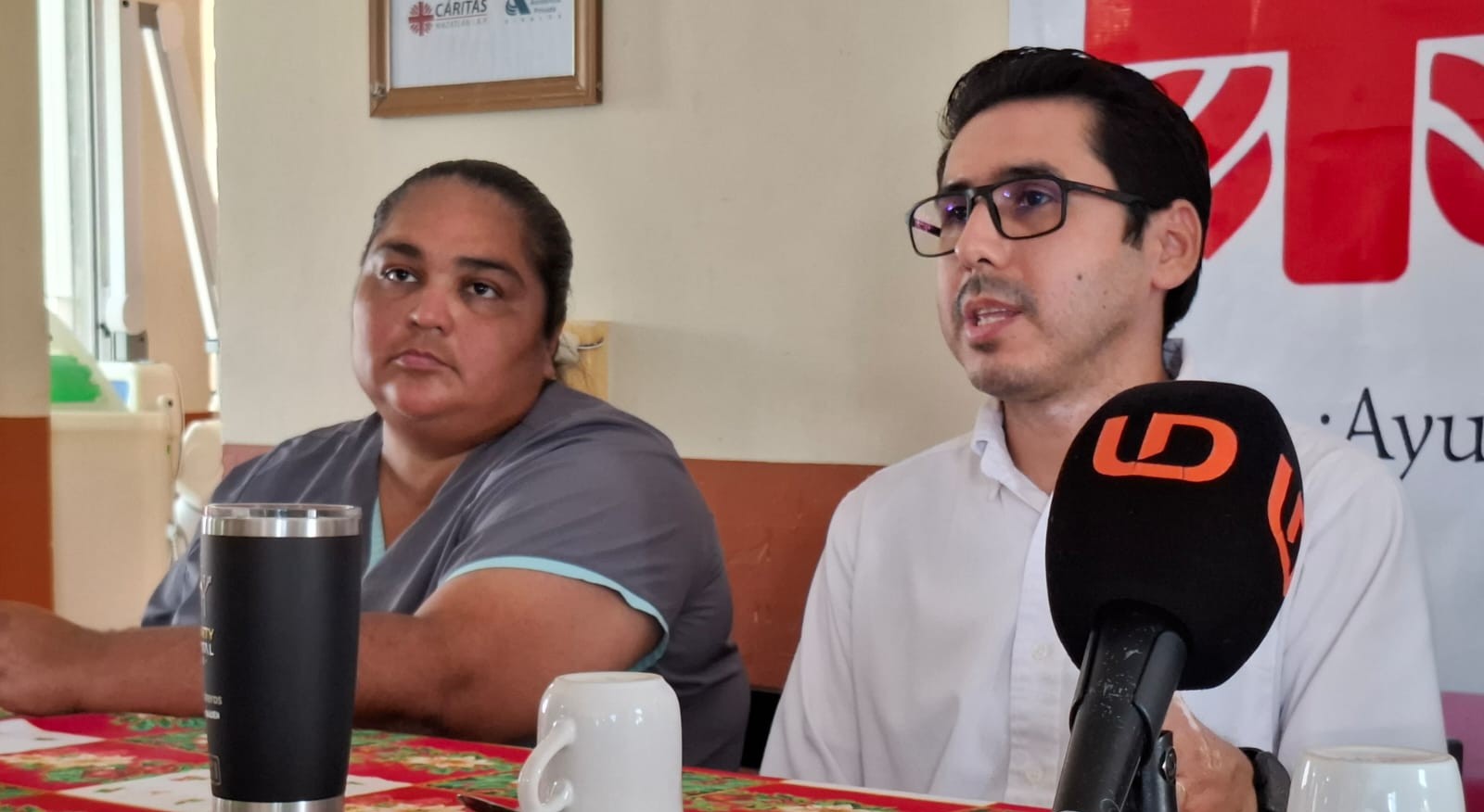 Dos personas en conferencia de prensa sobre Cáritas Diocesano Mazatlán
