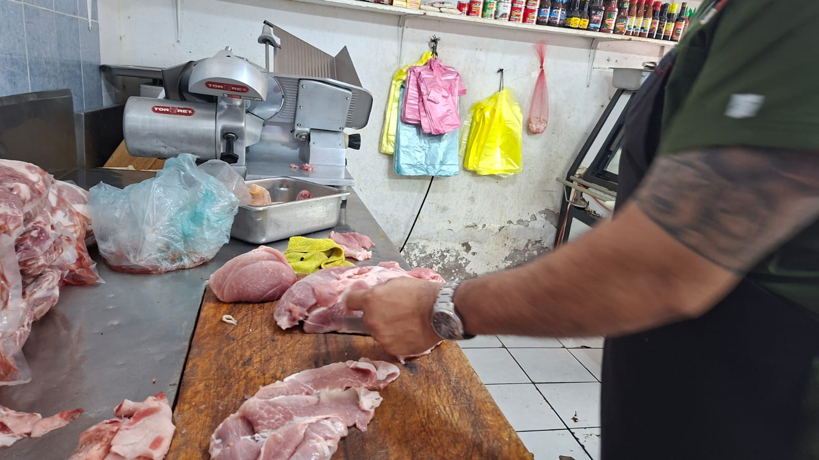 Una persona cortando pedazos de carne