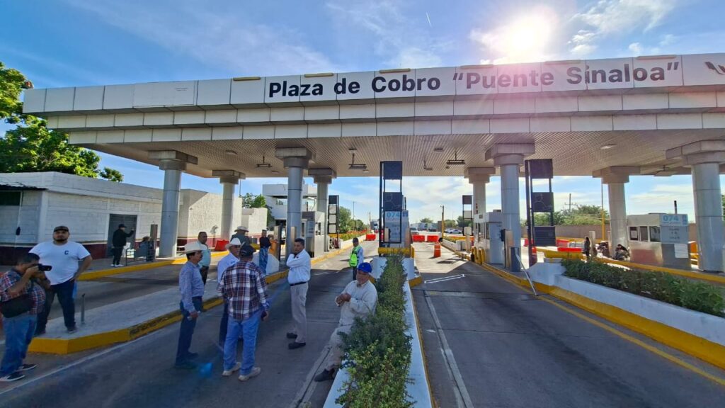 Personas bloqueando el camino en la caseta de cobro Cuatro Caminos
