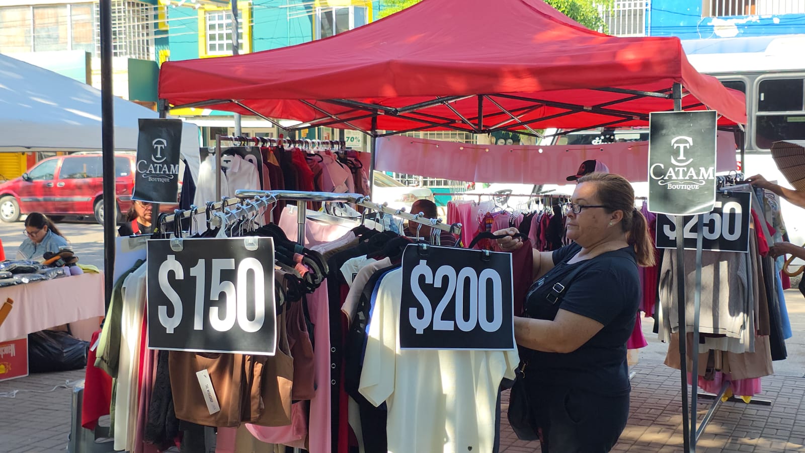 Mujer viendo ropa colgada en un negocio