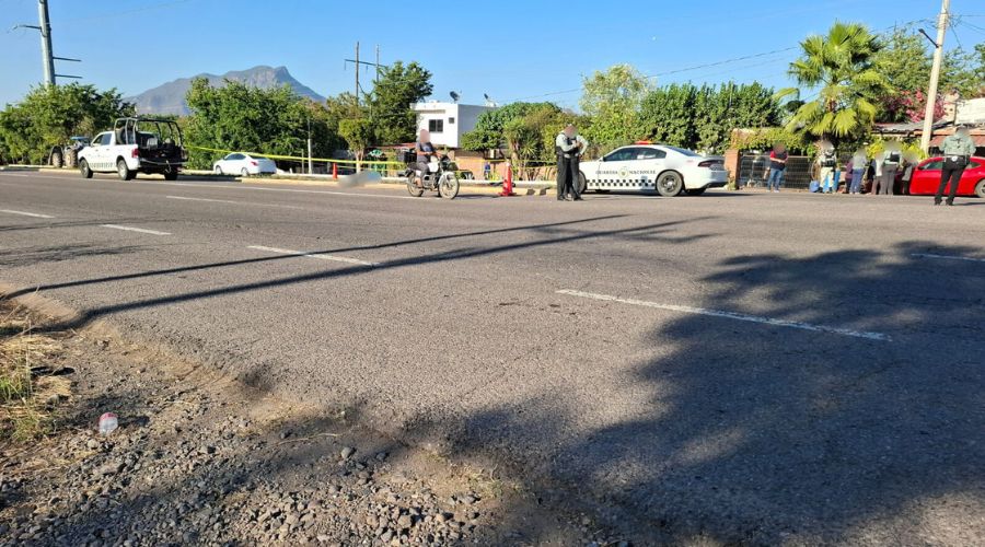 Calle con unidades de la Guardia Nacional, autos y más personas. Se observa una cinta de precaución amarilla