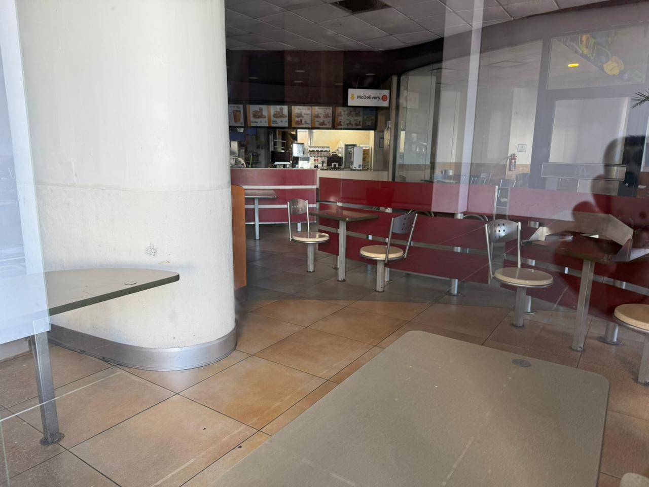 Restaurante de comida rápida completamente vacío por dentro y con las luces apagadas