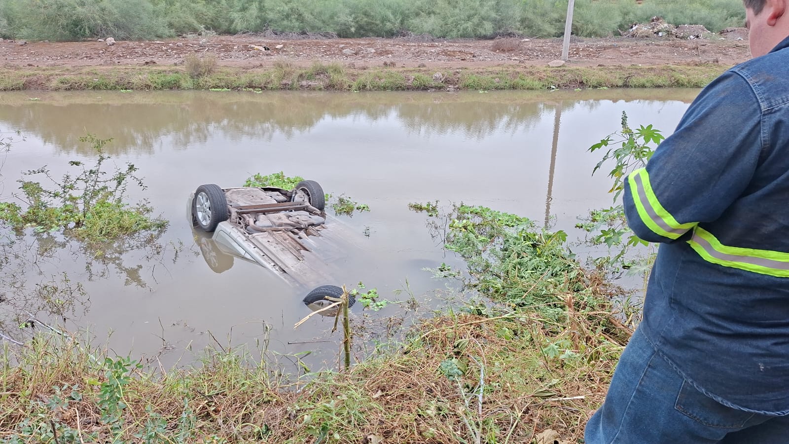Automóvil volteado dentro de un canal
