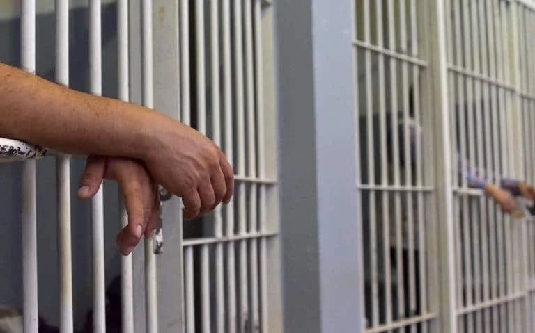 Personas en celda de detención