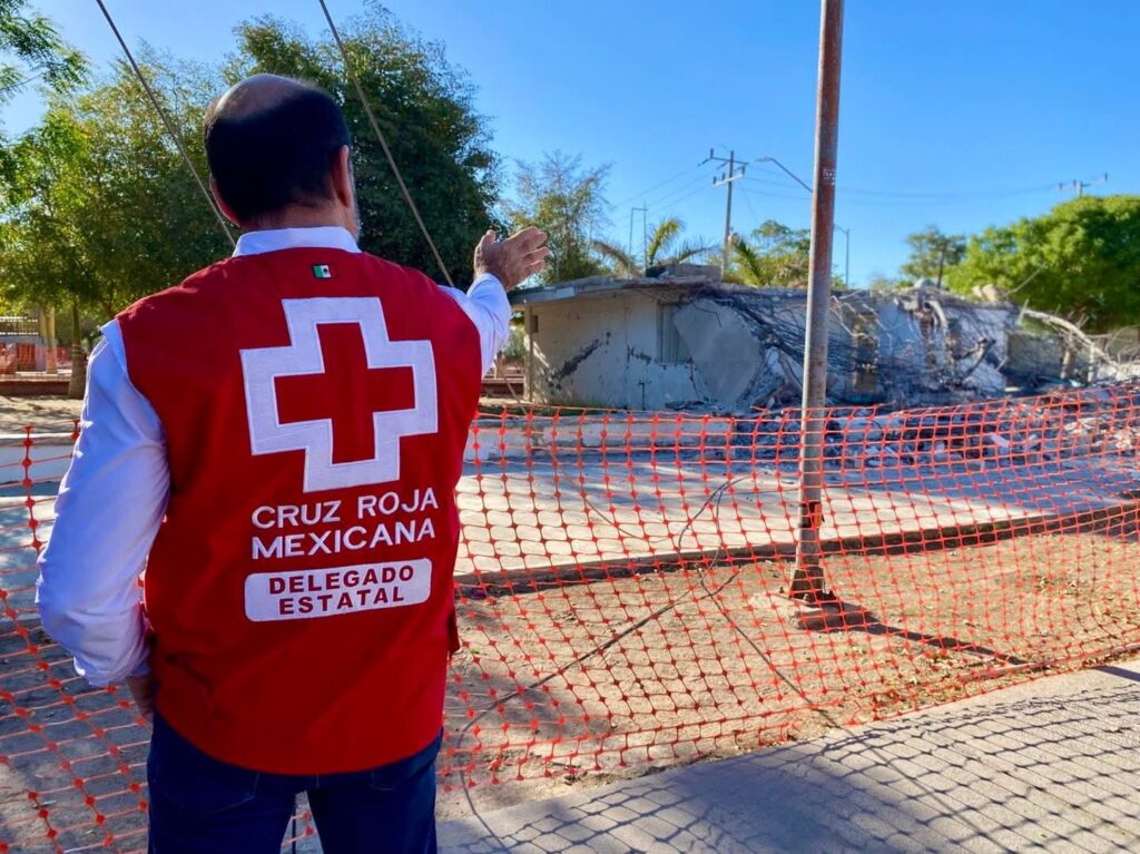 Persona con el chaleco de Cruz Roja y malla naranja