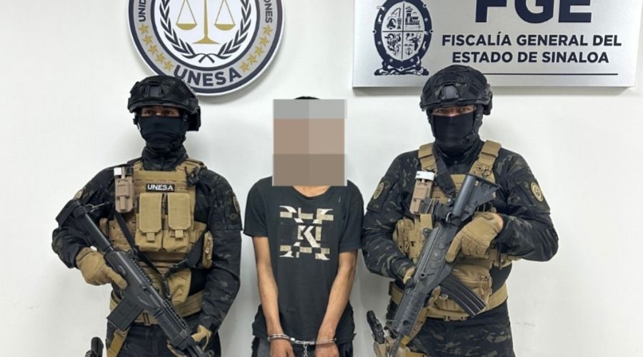 Dos elementos de seguridad junto a una persona con blur en la cara