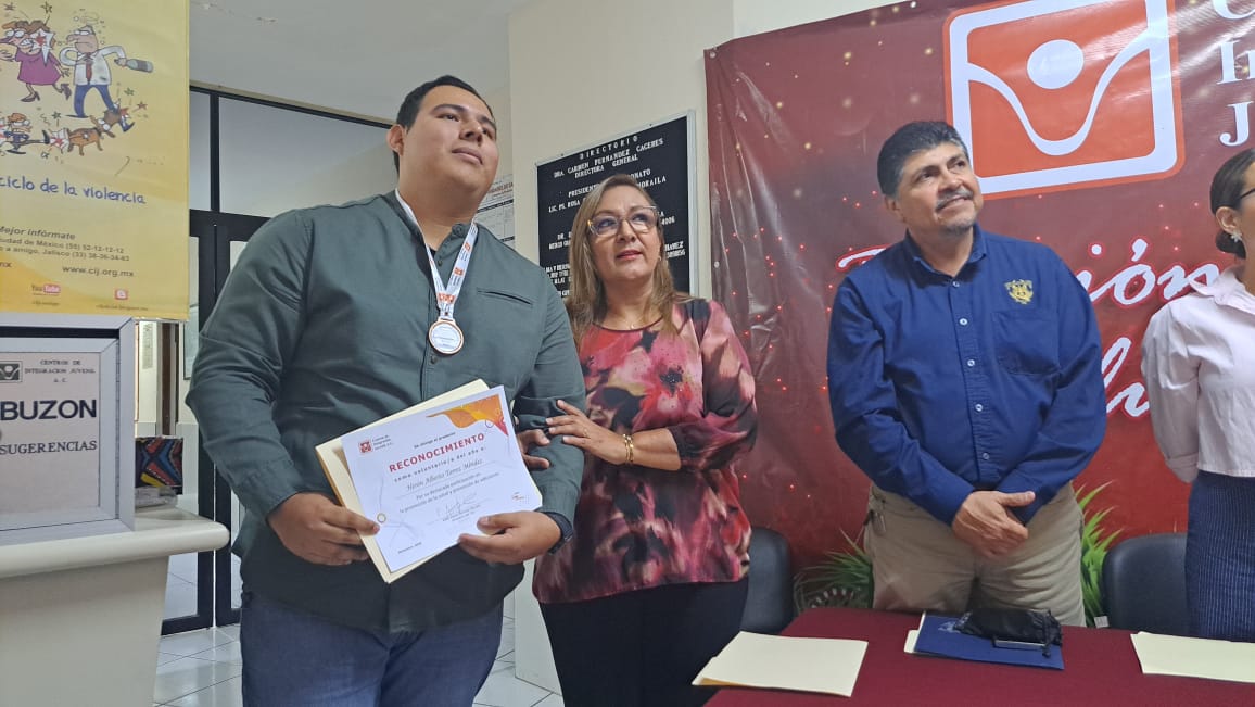 Representante de Centro de Integración Juvenil junto a Herón Torres entregándole un reconocimiento