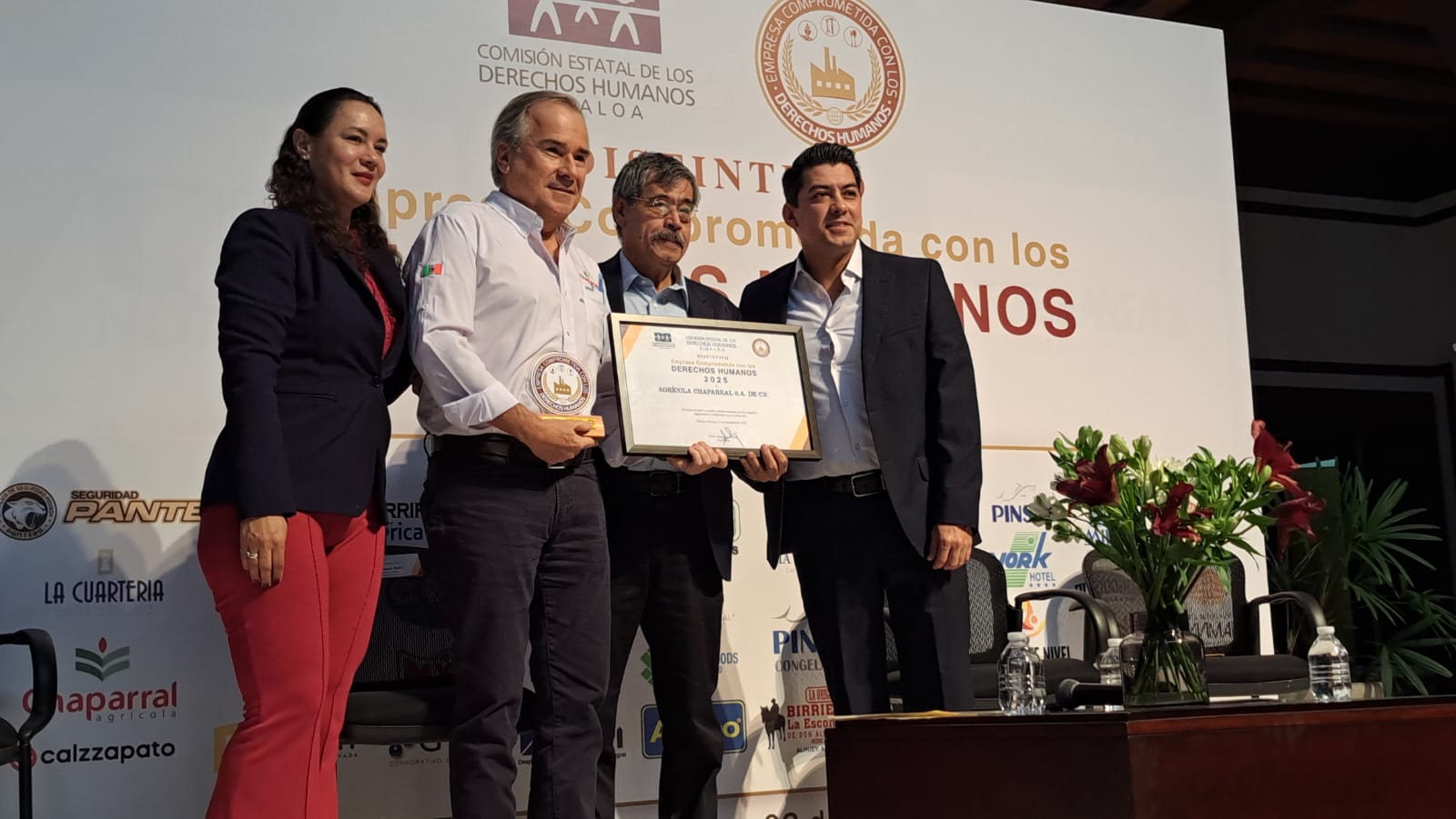 Autoridades de Comisión Estatal de Derechos Humanos de Sinaloa haciendo entrega de un reconocimiento a una empresario, posando para la foto