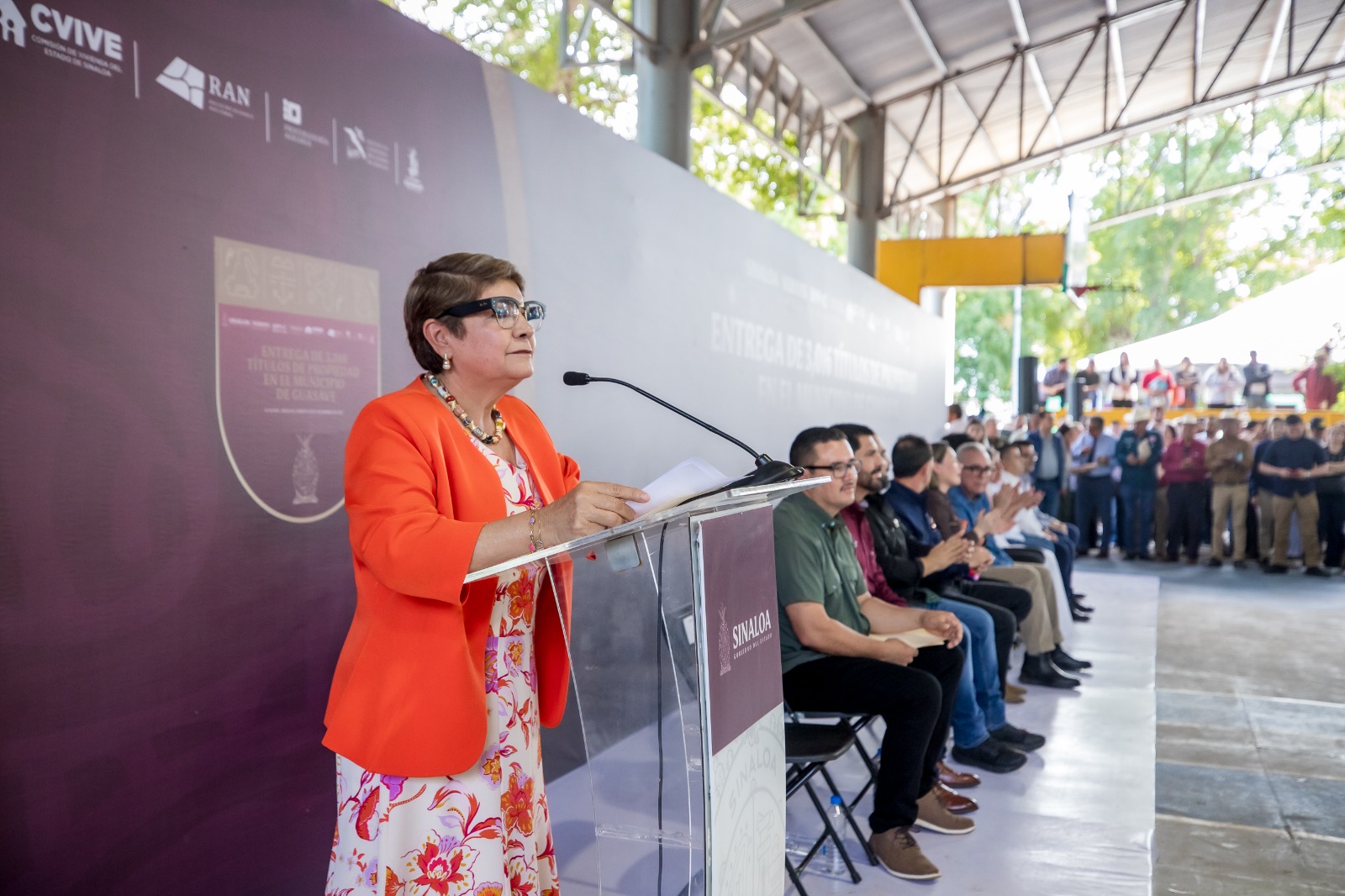 Cecilia Ramírez frente al micrófono en un evento con funcionarios
