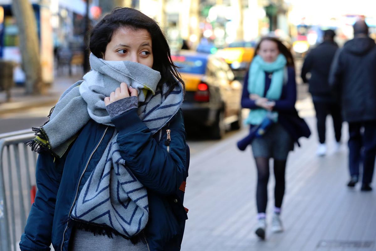 Personas abrigadas con bufandas y chamarra caminando