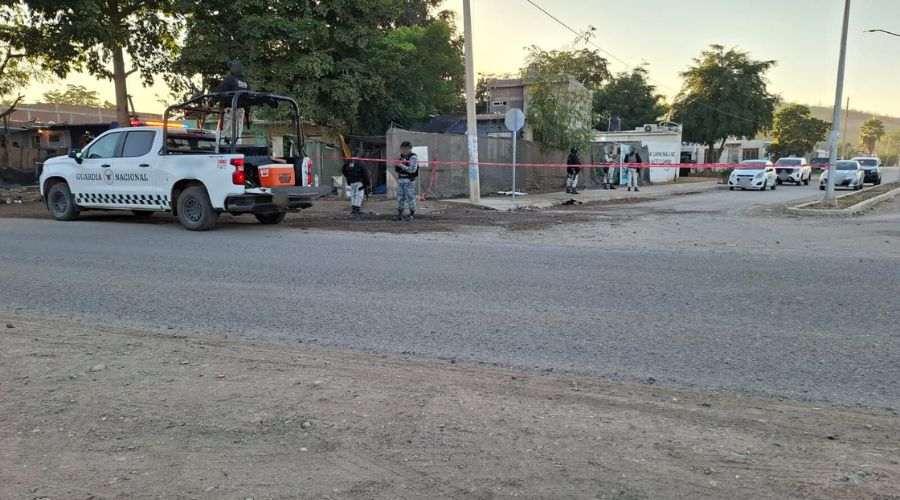 Personal de la Guardia Nacional junto a unidades policiacas en una calle con una cinta roja de precaución asegurando la zona