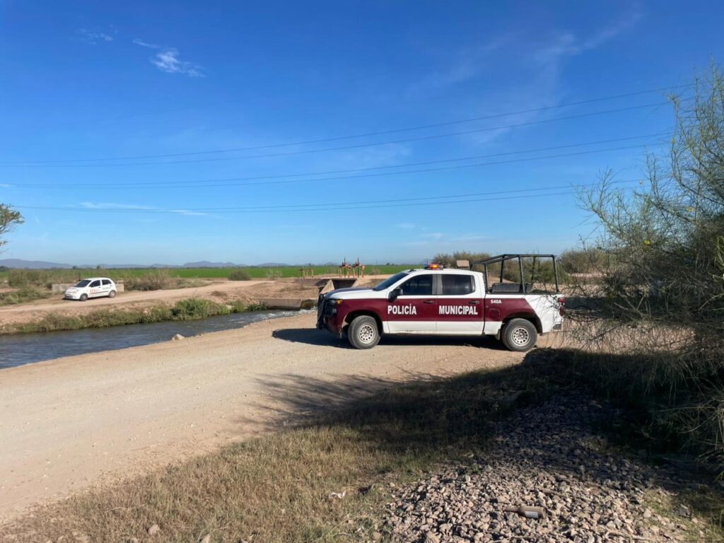 Patrulla de la Policía Municipal de Ahome a un lado del canal