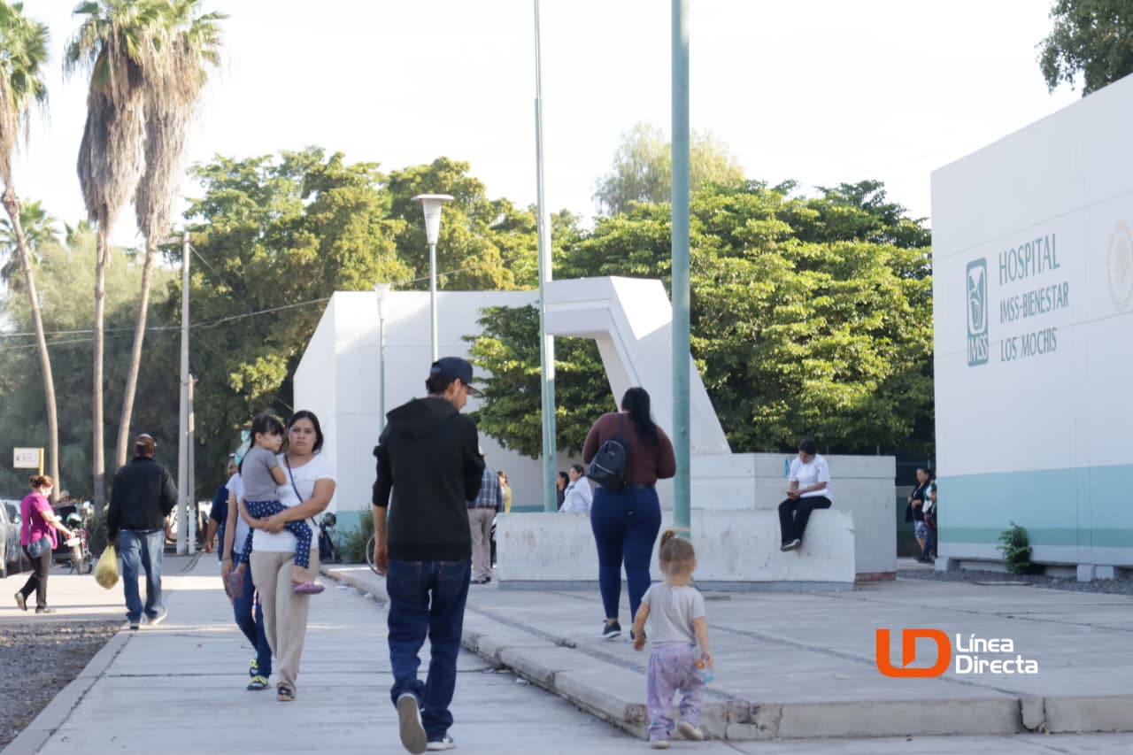 PErsonas caminando afuera de un hospital