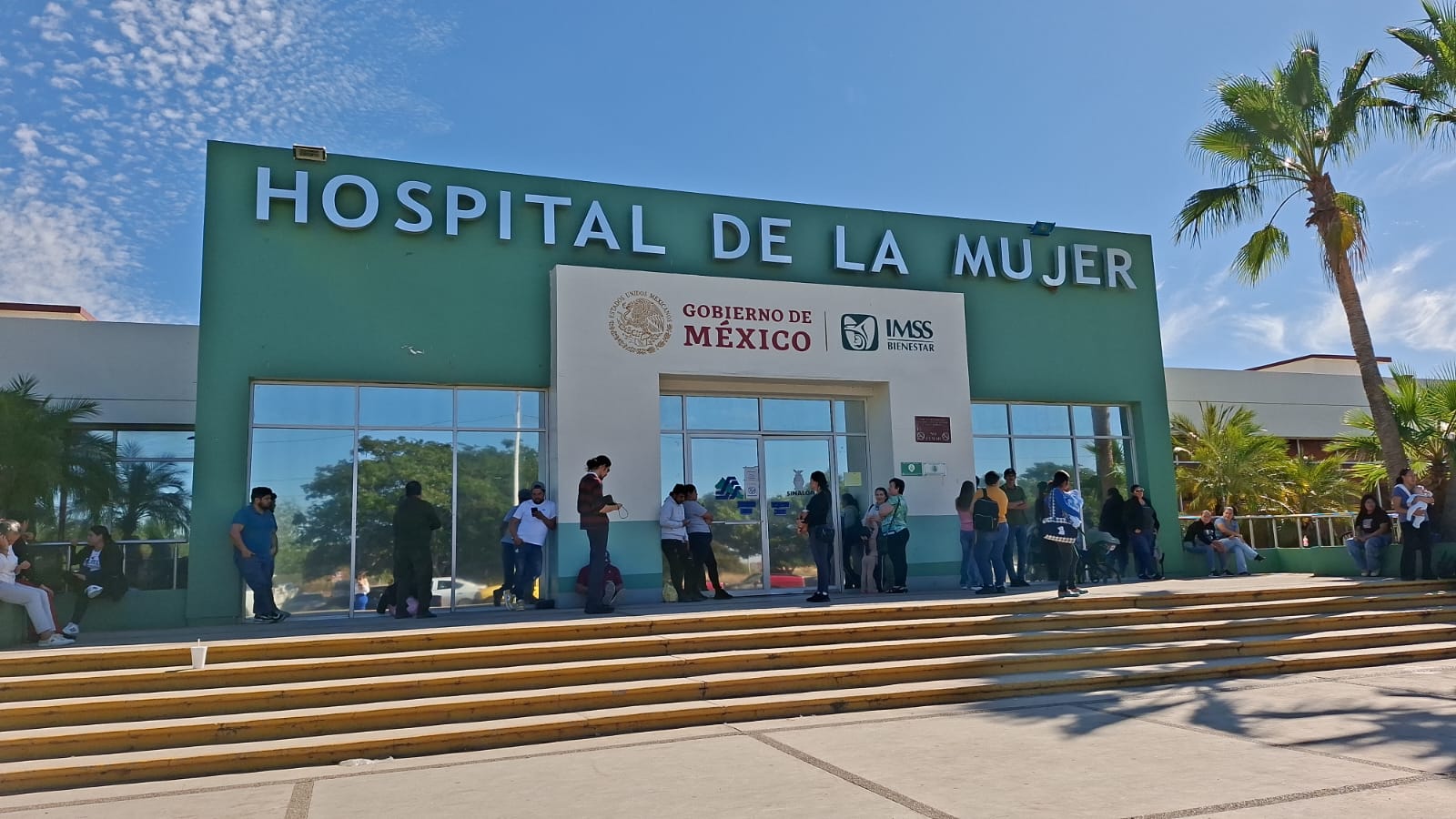 Fachada de un hospital con personas caminando