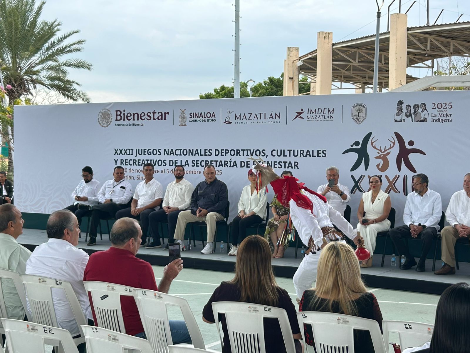 Autoridades del municipio de Mazatlán, sentados en el presidio, mientras hay una persona bailando una danza típica de la región